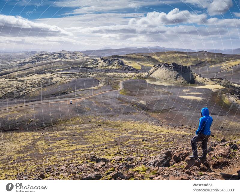 Männlicher Tourist bewundert Landschaft, während er auf einem Felsen steht, Lakagigar, Island Farbaufnahme Farbe Farbfoto Farbphoto Außenaufnahme außen draußen