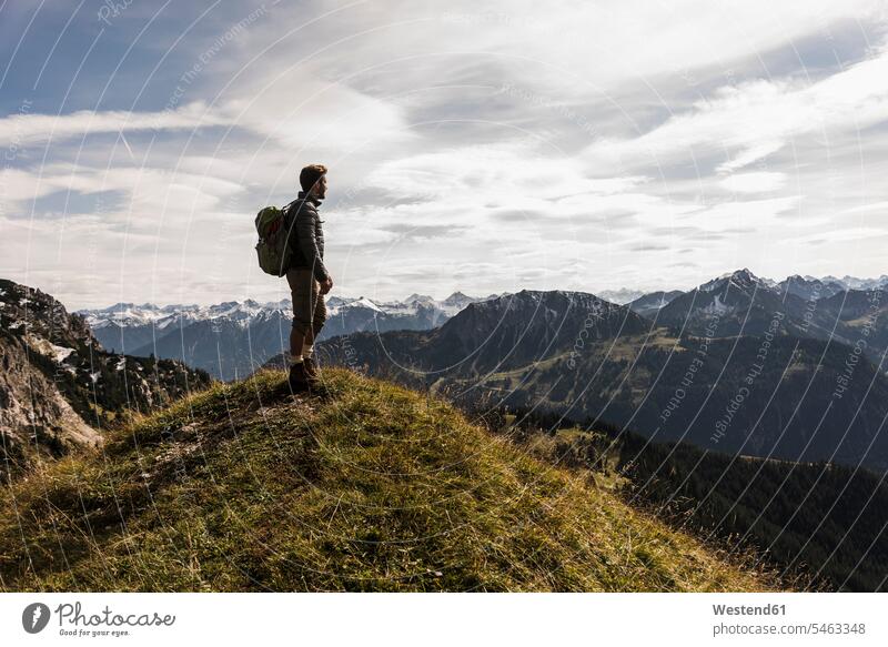 Österreich, Tirol, junger Mann steht in Berglandschaft und schaut auf Ansicht stehen stehend Berge Aussicht Ausblick Überblick Männer männlich wandern Wanderung