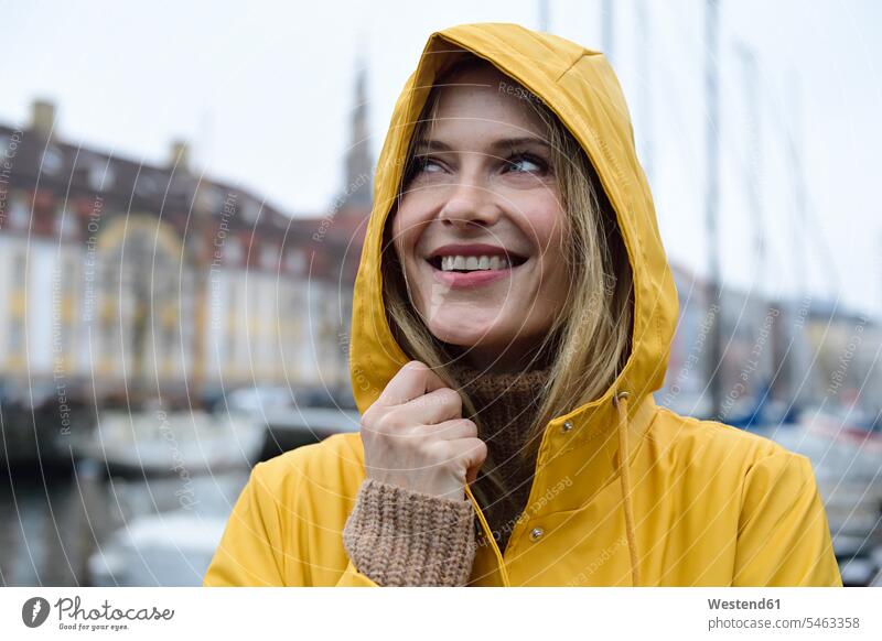 Dänemark, Kopenhagen, Porträt einer glücklichen Frau am Stadthafen bei regnerischem Wetter staedtisch städtisch weiblich Frauen Regenwetter Hafen Haefen Häfen