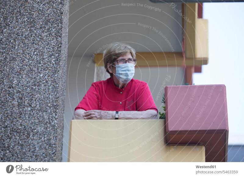 Ältere Frau mit Maske auf dem Balkon, Altersheim Brillen Erwartung sehnsüchtig Streben gefühlvoll Emotionen Empfindung Empfindungen fühlen Gefühl Gefühle