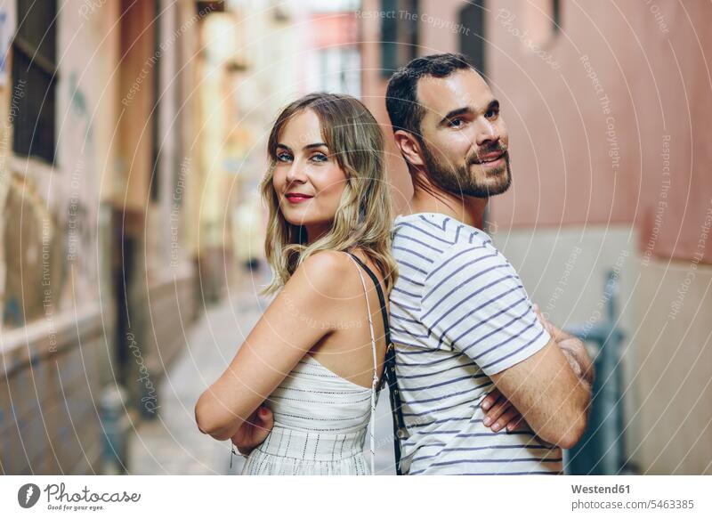 Spanien, Andalusien, Malaga, Porträt eines Touristenpaares, das Rücken an Rücken in der Stadt steht staedtisch städtisch Portrait Porträts Portraits stehen