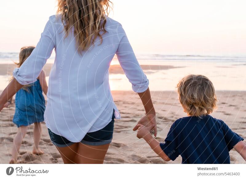 Mutter mit Kindern läuft bei Sonnenuntergang zum Meer Farbaufnahme Farbe Farbfoto Farbphoto Außenaufnahme außen draußen im Freien Sonnenuntergänge Stimmung