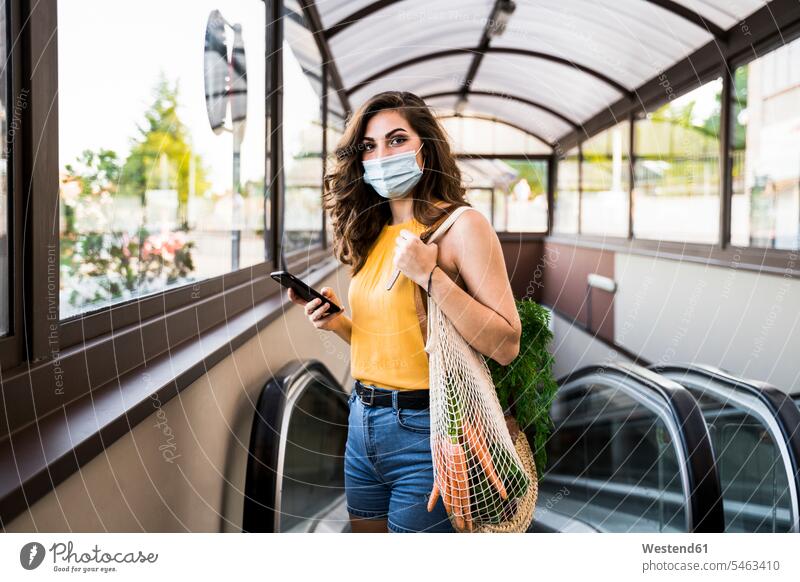 Junge Frau steht mit Gemüse in Netzbeutel gegen Fahrsteig in der U-Bahn Farbaufnahme Farbe Farbfoto Farbphoto Spanien Freizeitbeschäftigung Muße Zeit Zeit haben