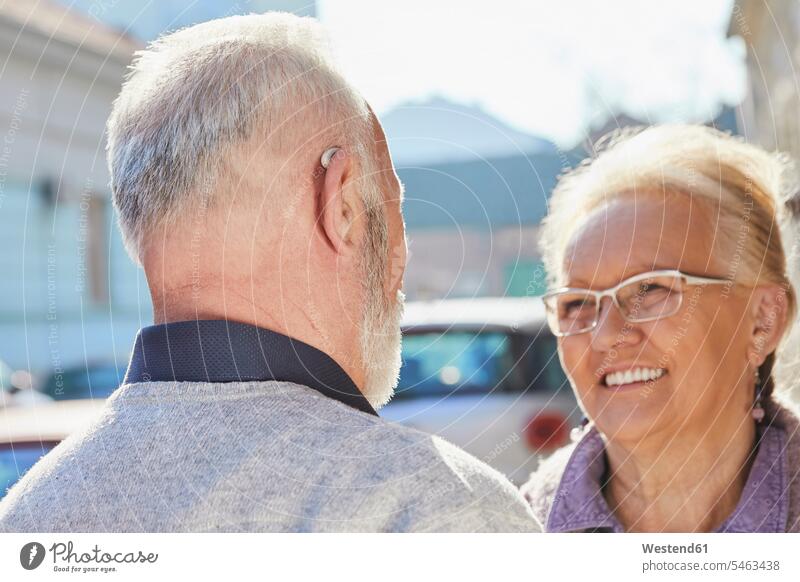 Nahaufnahme eines älteren Mannes mit Hörgerät im Gespräch mit einer älteren Frau Seniorin Seniorinnen alt Hörgeräte Hoergeraet Hoergeraete ältere Männer