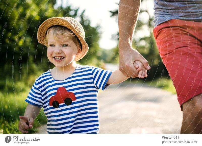 Porträt eines lachenden Kleinkindes, das an der Hand des Vaters läuft Kleinkinder Kindergartenalter Vorschulalter gehen gehend geht Hände Kid Kiddies Kids