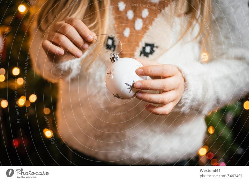 Den Weihnachtsbaum schmücken, Mädchen hält eine weiße Kugel mit silbernen Sternen Leute Menschen People Person Personen Europäisch Kaukasier kaukasisch 1 Ein
