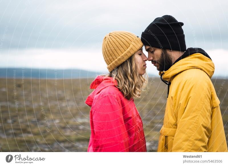 Junges Paar reibt sich liebevoll an der Nase, Lappland, Norwegen Nordkap zaertlich einfühlsam einfuehlsam zärtlich sanft Nasen reiben Nase reiben Eskimokuss
