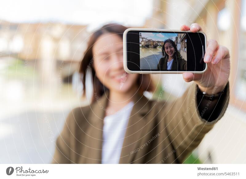 Italien, Florenz, junge Touristin, die ein Selfie am Ponte Vecchio macht Fokus Auf Den Vordergrund Fokus Auf Dem Vordergrund Teilen Sharing Foto Fotos Selfies