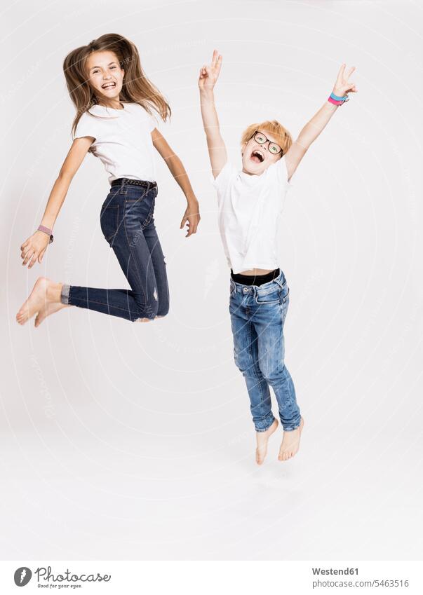 Fröhliche Geschwister springen vor weißem Hintergrund 12-13 Jahre 12 bis 13 Jahre 12 - 13 Jahre Kinder Kid Kids Kiddies Mensch Menschen Person Personen Leute