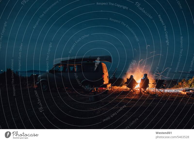 Kanada, Britisch-Kolumbien, Prinz Rupert, zwei Männer sitzen nachts am Lagerfeuer im Minivan Nacht Mann männlich Feuer Erwachsener erwachsen Mensch Menschen