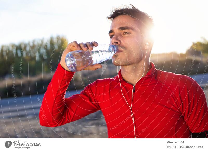 Junger Jogger trinkt aus einer Wasserflasche Leute Menschen People Person Personen Europäisch Kaukasier kaukasisch 1 Ein ein Mensch nur eine Person single