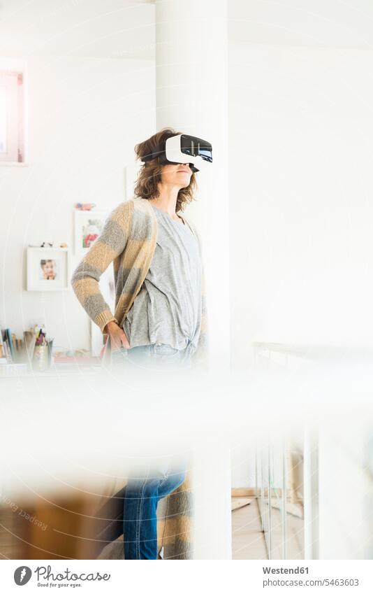 Frau trägt VR-Brille zu Hause weiblich Frauen Brillen Virtuelle Realität Virtuelle Realitaet Zuhause daheim Erwachsener erwachsen Mensch Menschen Leute People