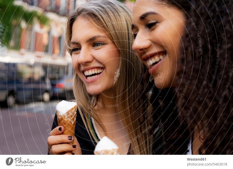 Zwei lachende Freundinnen, die Spaß haben und Eis essen Eiscreme Speiseeis Städtereise City Trip Kurztripp City Break reisen Travel verreisen Weg Reise