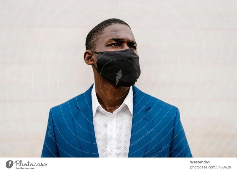 Männlicher Berufstätiger, der während der COVID-19-Pandemie eine schützende Gesichtsmaske gegen die Wand trägt Farbaufnahme Farbe Farbfoto Farbphoto Spanien