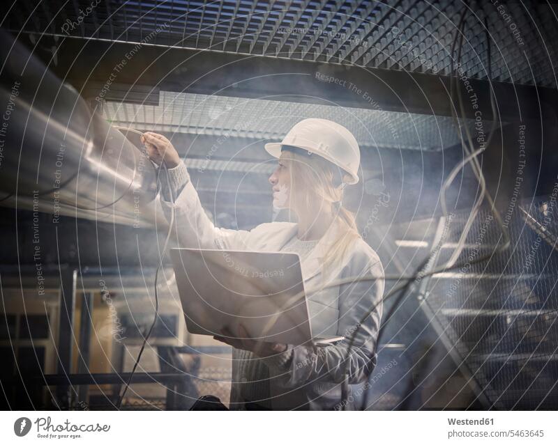 Technikerinnen, die an Rohrleitungen arbeiten, mit Laptop Leitung Leitungen Industrie industriell Gewerbe Industrien Arbeit Frau weiblich Frauen Notebook