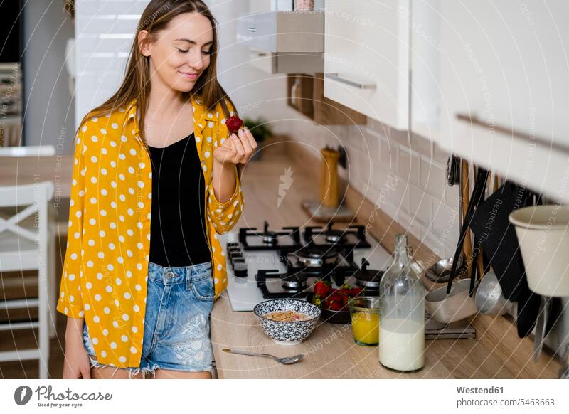 Junge Frau frühstückt zu Hause in der Küche Leute Menschen People Person Personen Alleinstehende Alleinstehender Singles Unverheiratete Unverheirateter Flaschen