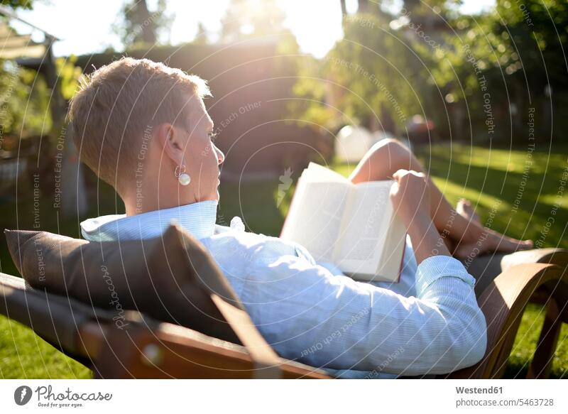 Frau auf Liegestuhl liest Buch im Garten Bücher Gärten Gaerten lesen Lektüre Liegestühle weiblich Frauen Stuhl Stuehle Stühle Erwachsener erwachsen Mensch
