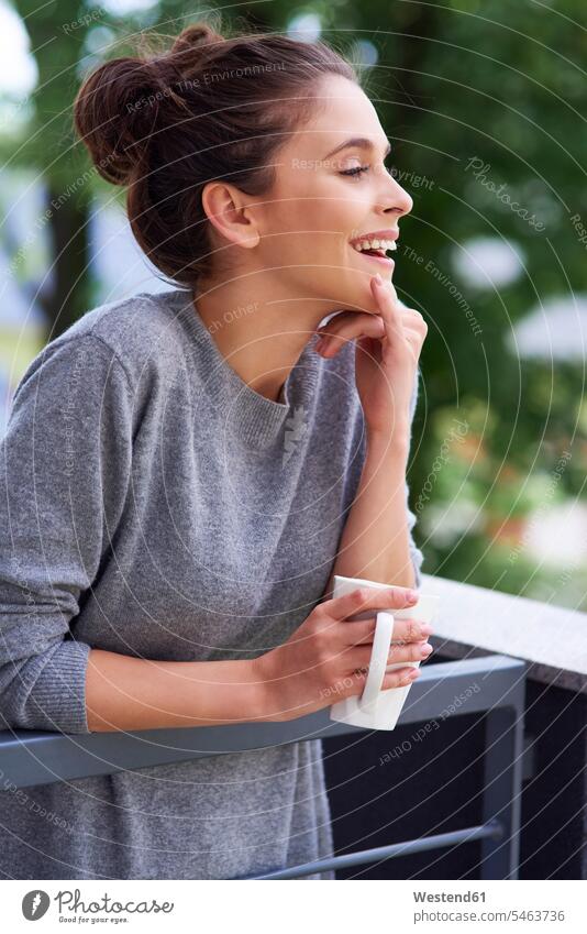 Junge Frau trinkt Morgenkaffee auf dem Balkon Kaffee stehen stehend steht Balkone lachen trinken junge Frau junge Frauen morgens früh Frühe Getränk Getraenk