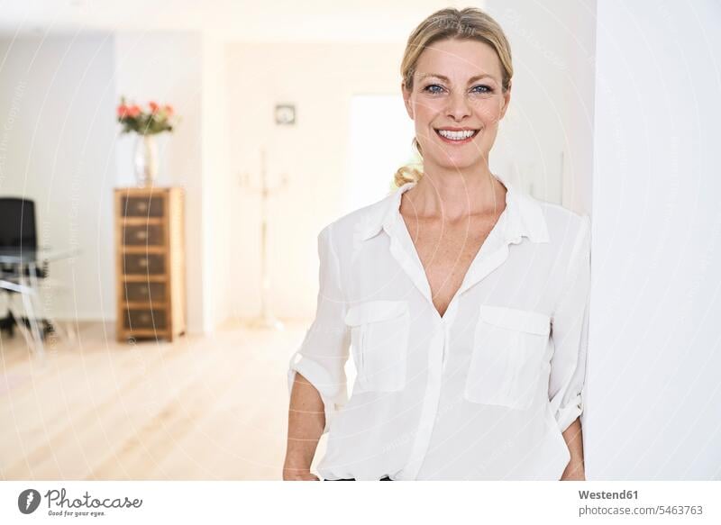 Porträt einer lächelnden Frau, die zu Hause eine weiße Bluse trägt Blusen weiblich Frauen Zuhause daheim Portrait Porträts Portraits weißes weißer weiss