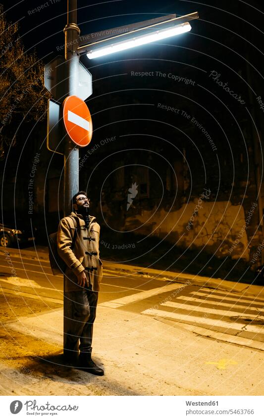 Spanien, Igualada, Mann steht unter einer Straßenlaterne bei Nacht Männer männlich Straßenlampe Straßenlampen Straßenlaternen Straßenbeleuchtung stehen stehend