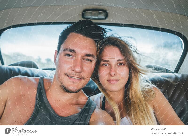 Kuba, ein junges Paar sitzt in einem Oldtimer und macht ein Selfie Selfies unterwegs auf Achse in Bewegung fotografieren Auto Wagen PKWs Automobil Autos