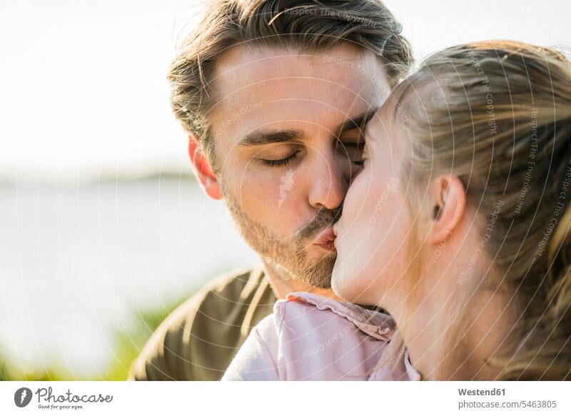Zärtliches Paar küsst sich im Freien Zuneigung Pärchen Paare Partnerschaft küssen Küsse Kuss Mensch Menschen Leute People Personen Augen geschlossen