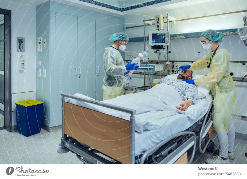 Ärzte, die Patienten auf der Notfallstation eines Krankenhauses betreuen, wechseln die Atmung von Sauerstoffmaske auf Beutelventilmaske Arbeitskollege