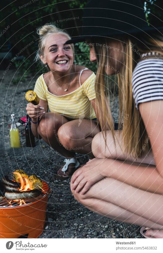 Zwei glückliche junge Frauen beim Grillen grillen Gemeinsam Zusammen Miteinander Barbecue Grillparties Grillfest Grillfeste Grillparty Freundinnen weiblich