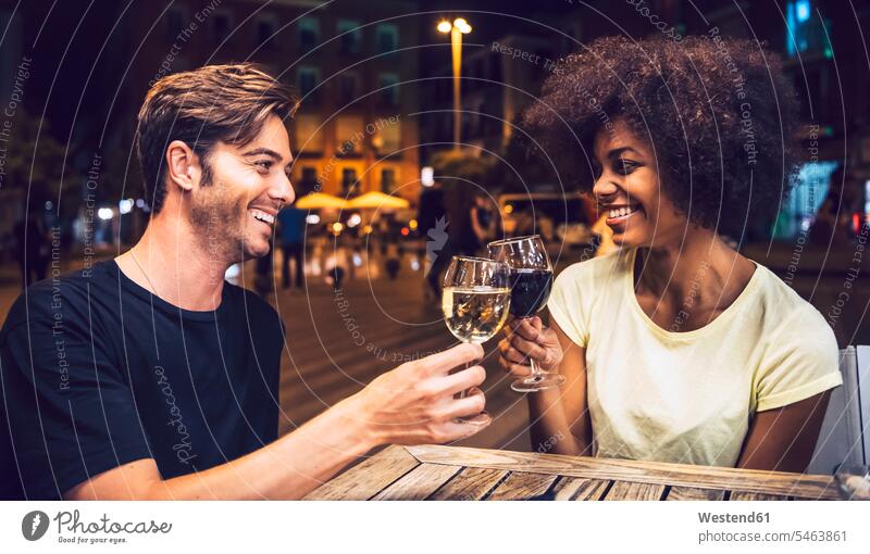 Fröhliches Paar schaut sich an, während es am Date-Night auf Weingläser anstößt Farbaufnahme Farbe Farbfoto Farbphoto Spanien Freizeitbeschäftigung Muße Zeit