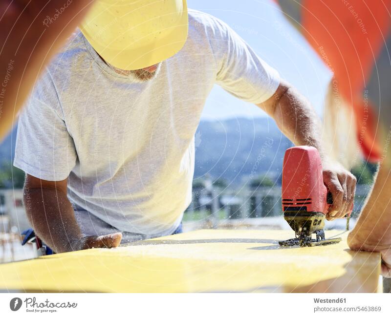 Bauarbeiter schneidet Sperrholz mit der Stichsäge auf der Baustelle schneiden Schalungsplatte Schaltafel Baustellen Handwerker Handwerksberuf Handwerksberufe