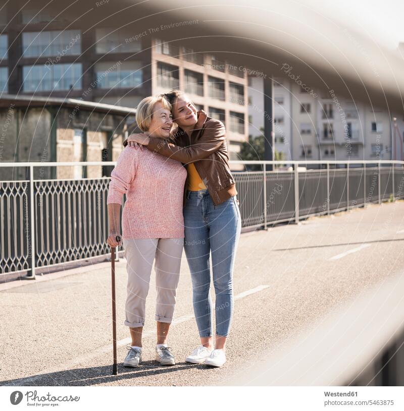 Enkelin und ihre Großmutter stehen auf dem Steg Generation Arm umlegen Umarmung Umarmungen freuen Glück glücklich sein glücklichsein innig nah zufrieden Farben