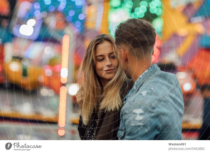 Junges verliebtes Paar, das sich auf einem Jahrmarkt umarmt Volksfest Rummelplatz Kirmes küssen Küsse Kuss Junges Paar Junge Paare umarmen Umarmung Umarmungen