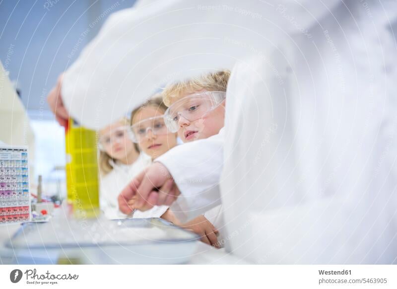 Schülerinnen und Schüler im naturwissenschaftlichen Unterricht beobachten Lehrer beim Experimentieren experimentieren Schule Schulen Naturwissenschaftskurs