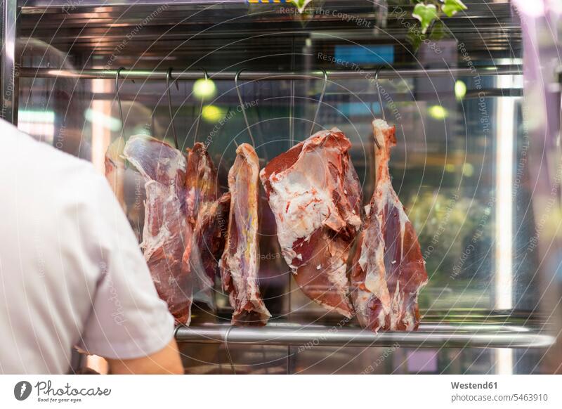 Serrano-Schinken an Haken hängend am Marktstand Beruf Berufstätigkeit Berufe Beschäftigung Jobs Fleischwaren Regionale Küche regional Senior ältere Männer
