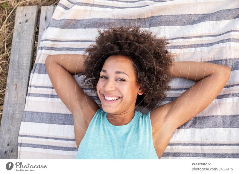 Porträt einer glücklichen Frau auf einer Decke liegend im Freien Decken lächeln Glück glücklich sein glücklichsein Portrait Porträts Portraits liegt weiblich