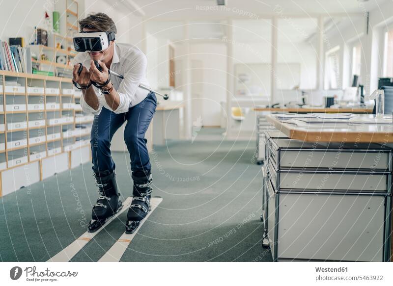 Geschäftsmann beim Skifahren im Büro, mit VR-Brille Skis Schi Schier Skier Skisport Urlaub Ferien spielen Skifahrer Schifahrer Schiläufer Skiläufer Skilaeufer