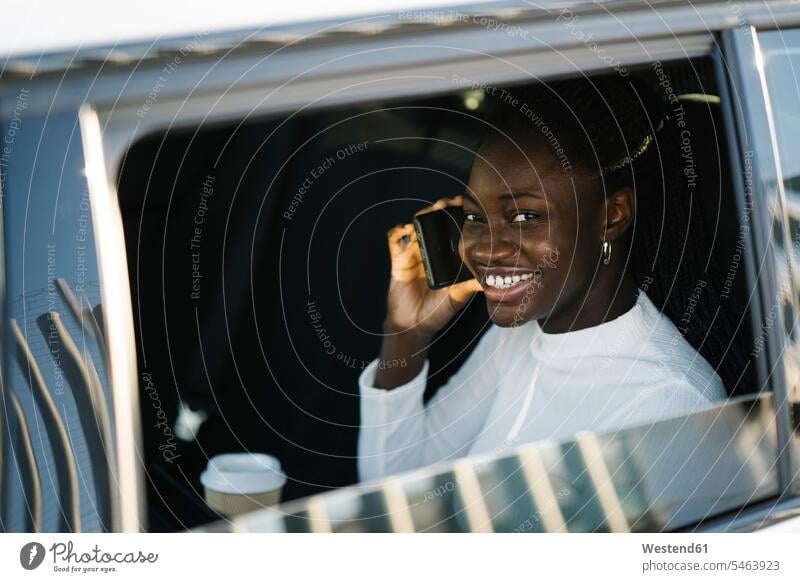 Lächelnde Teenagerin beim Telefonieren durch Autofenster gesehen Farbaufnahme Farbe Farbfoto Farbphoto Außenaufnahme außen draußen im Freien Tag