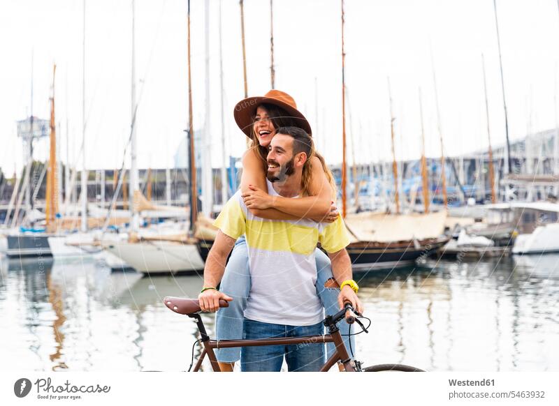 Spanien, Barcelona, glückliches Paar mit Fahrrad am Meer Küste Küstenlandschaft Bikes Fahrräder Räder Rad Pärchen Paare Partnerschaft Glück glücklich sein