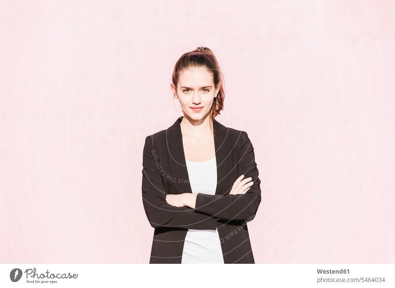 Porträt einer selbstbewussten jungen Frau vor einer rosa Wand Portrait Porträts Portraits weiblich Frauen rosafarben Zuversicht Zuversichtlich Selbstvertrauen
