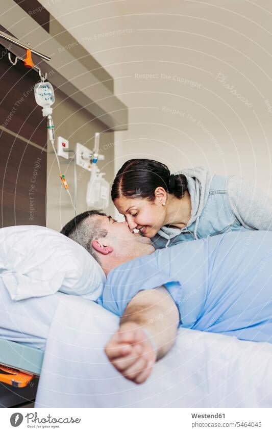 Liebevolle Frau besucht Ehemann im Krankenhausbett liegend Leute Menschen People Person Personen Europäisch Kaukasier kaukasisch 2 2 Menschen 2 Personen zwei