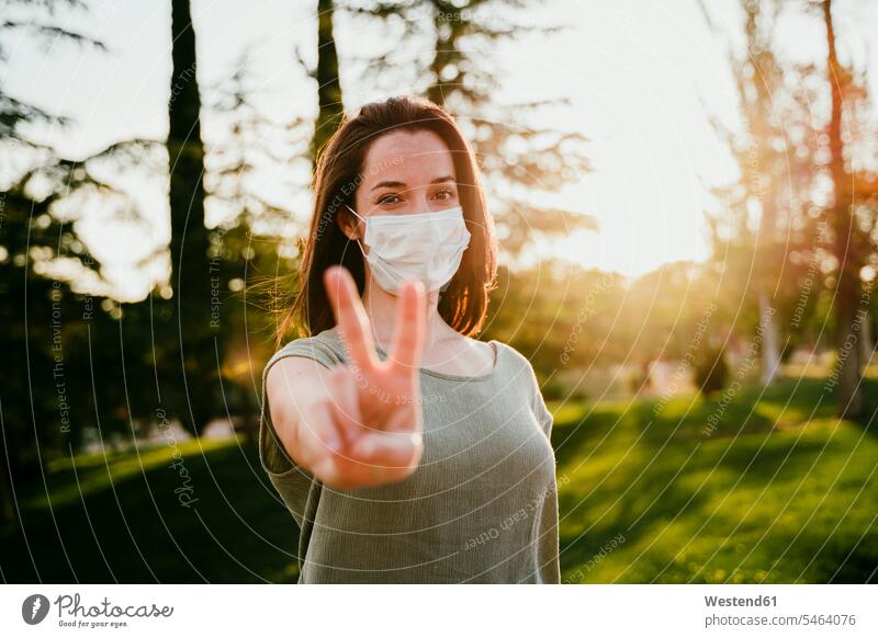 Bildnis einer Frau mit Schutzmaske in der Natur mit Siegeszeichen gewinnen auf dem Land auf dem Lande Muße Geste gestikulieren Gesund Lifestyles geschützt