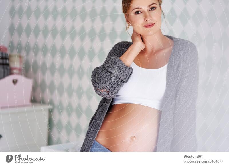 Porträt einer schwangeren Frau im Babyzimmer Bauch Bäuche Portrait Porträts Portraits weiblich Frauen Kinderzimmer Schwangere schwangere Frau lächeln Oberkörper