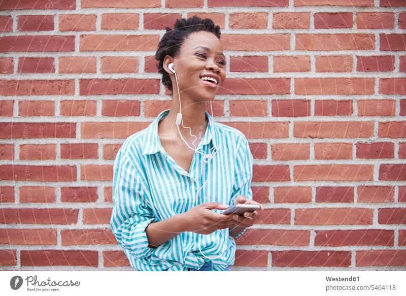 Porträt einer entspannten Frau, die Kopfhörer und Handy benutzt weiblich Frauen Smartphone iPhone Smartphones Portrait Porträts Portraits benutzen benützen