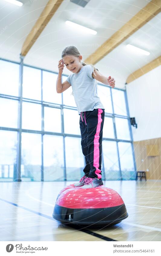 Schulmädchen balanciert auf Übungsgeräten im Sportunterricht balancieren Balance Schülerin Schuelerin Schülerinnen Schuelerinnen Schule Schulen Fitnessgerät