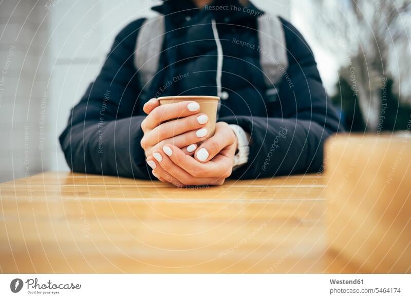 Frau trinkt Kaffee, während sie in einem Café in der Stadt sitzt Farbaufnahme Farbe Farbfoto Farbphoto Außenaufnahme außen draußen im Freien Tag