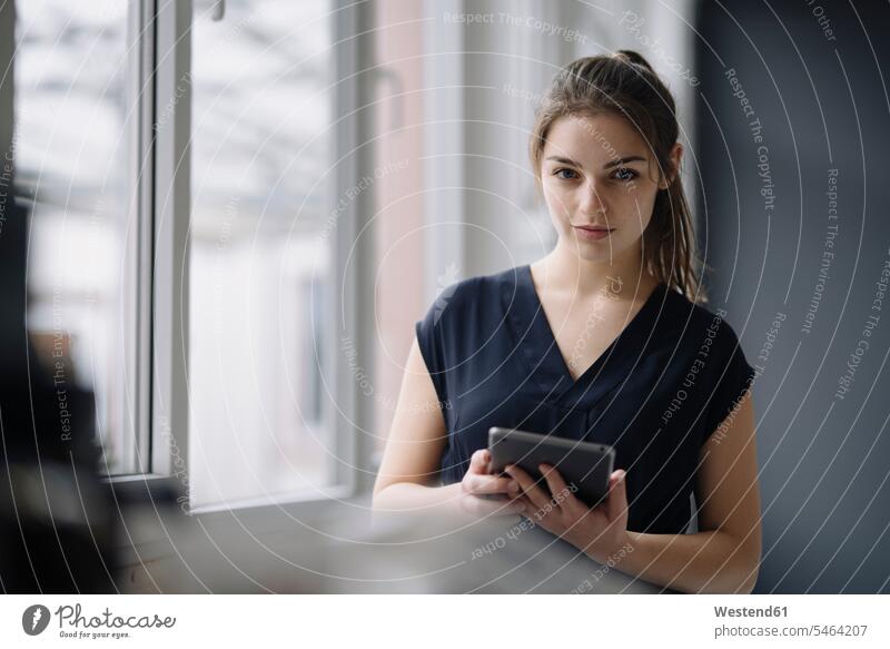 Porträt einer jungen Geschäftsfrau mit digitalem Tablett im Büro Leute Menschen People Person Personen Europäisch Kaukasier kaukasisch 1 Ein ein Mensch