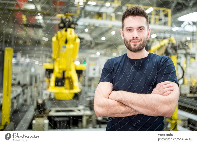 Porträt eines selbstbewussten Arbeiters in einer modernen Fabrik Job Berufe Berufstätigkeit Beschäftigung Jobs T-Shirts zufrieden stehend steht Arbeitsstätte