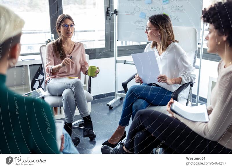 Geschäftsfrauen während eines Treffens an einem Flipchart Team Beruf Geschäftskleidung Kommunikation arbeiten sitzen sprechen Zufriedenheit Entwicklung Erfolg