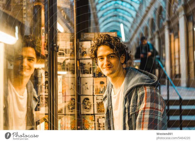 Porträt eines lächelnden jungen Mannes im Einkaufszentrum Tourist Touristen Männer männlich Städtereise City Trip Kurztripp City Break Individualität