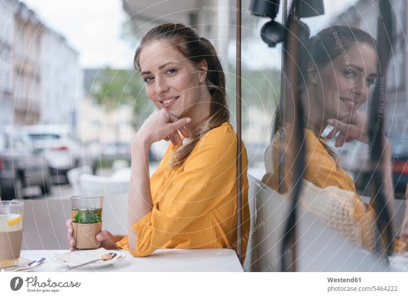 Frau sitzt im Kaffeehaus und trinkt Pfefferminztee weiblich Frauen Pfefferminztees trinken Erwachsener erwachsen Mensch Menschen Leute People Personen